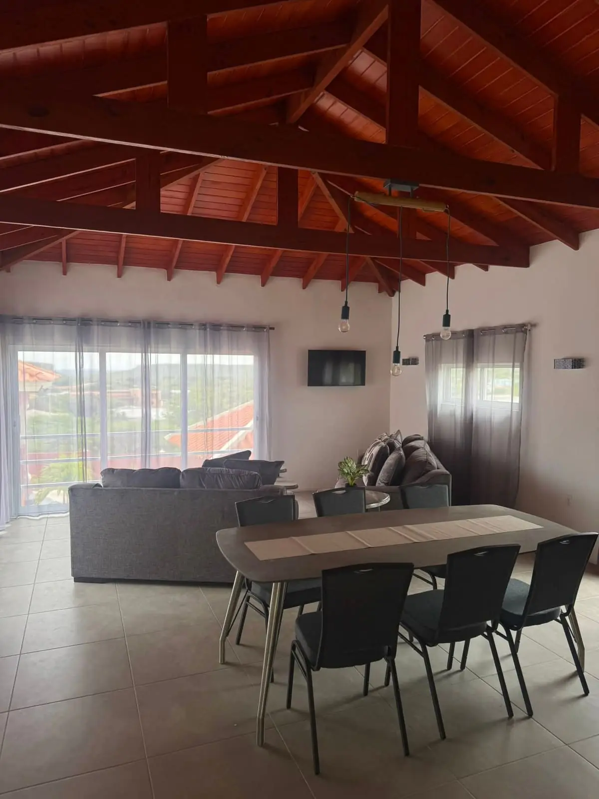 De woonkamer van de villa onder de open houten kap